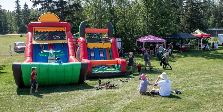 Families gathering near colourful inflatable play areas at the 2025 festival