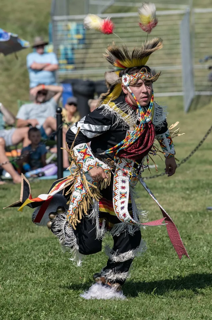 A dancer in regalia moving through the 2025 festival grounds