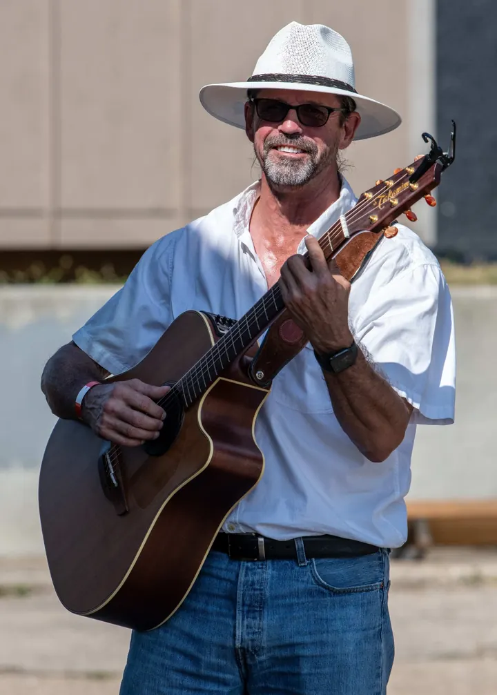 A guitarist performing on the outdoor stage in 2025