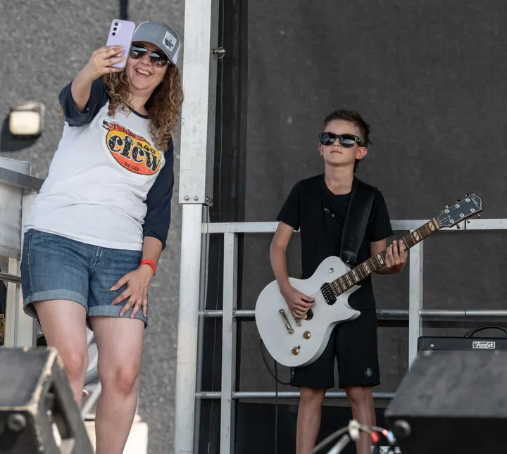 A young guitarist performing for the festival crowd in 2025