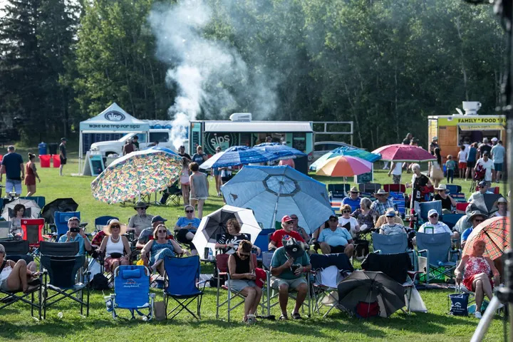 Festival guests spread across the grass in chairs and small groups in 2025