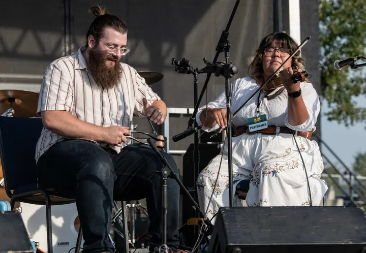 Two fiddle players performing side by side at the 2025 festival