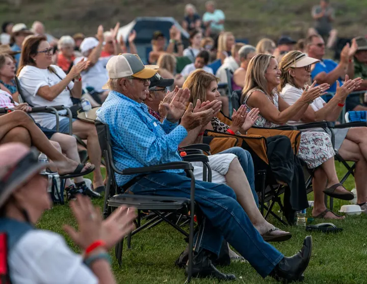 Audience members applauding from their lawn chairs in 2025