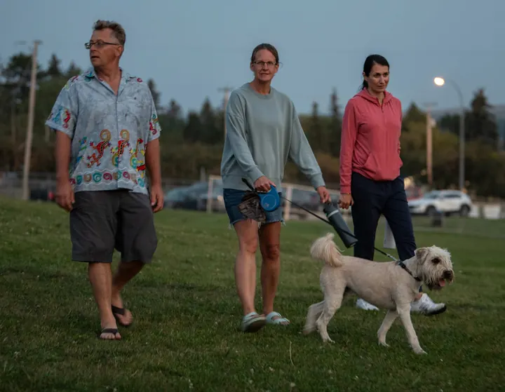 A family walking a dog across the festival grounds in 2025